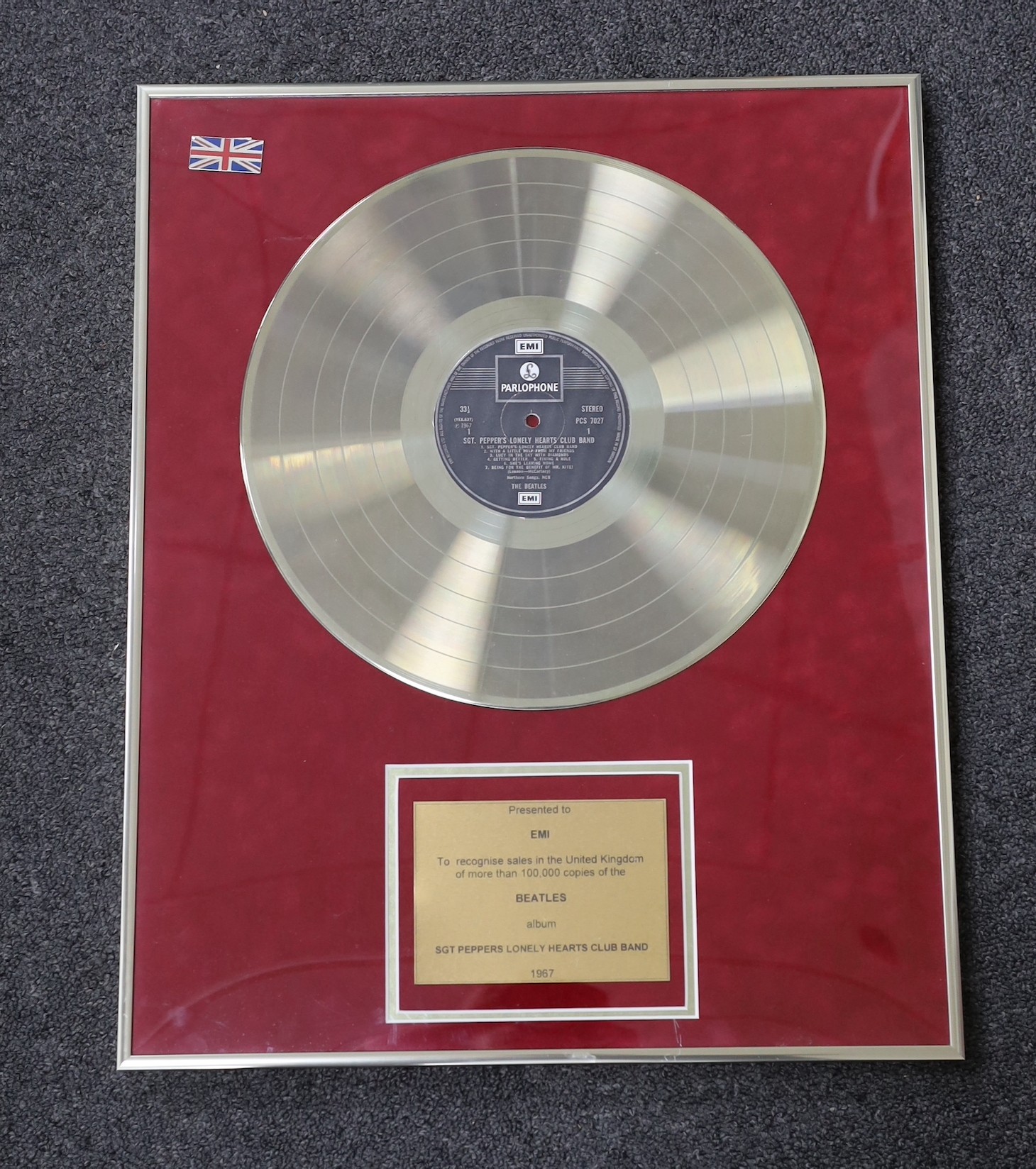 Sgt. Peppers Lonely Hearts Club Band, a framed gold disc, presented to EMI to recognise sales in the United Kingdom, of more than 100,000 copies, frame 41 x 50cm